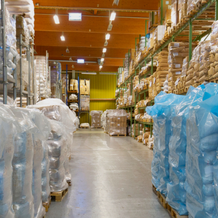 a large warehouse for raw materials in a hall with high racks in which a large number of sacks are stored