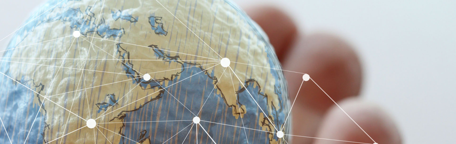 Close-up of a globe with white dots and lines showing company locations and worldwide connections