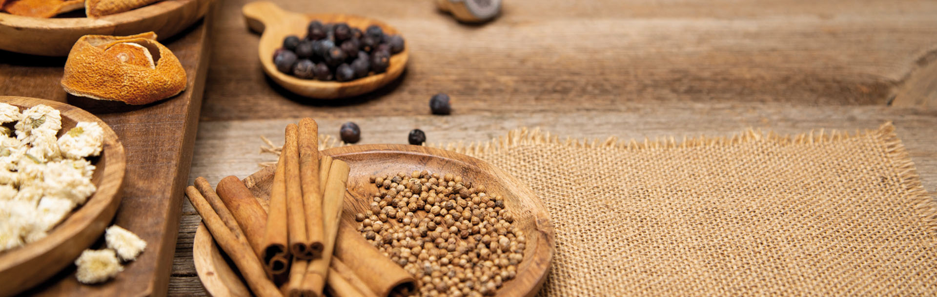 Dried orange peel, cinnamon sticks, blossoms and juniper berries are beautifully decorated in a wooden bowl